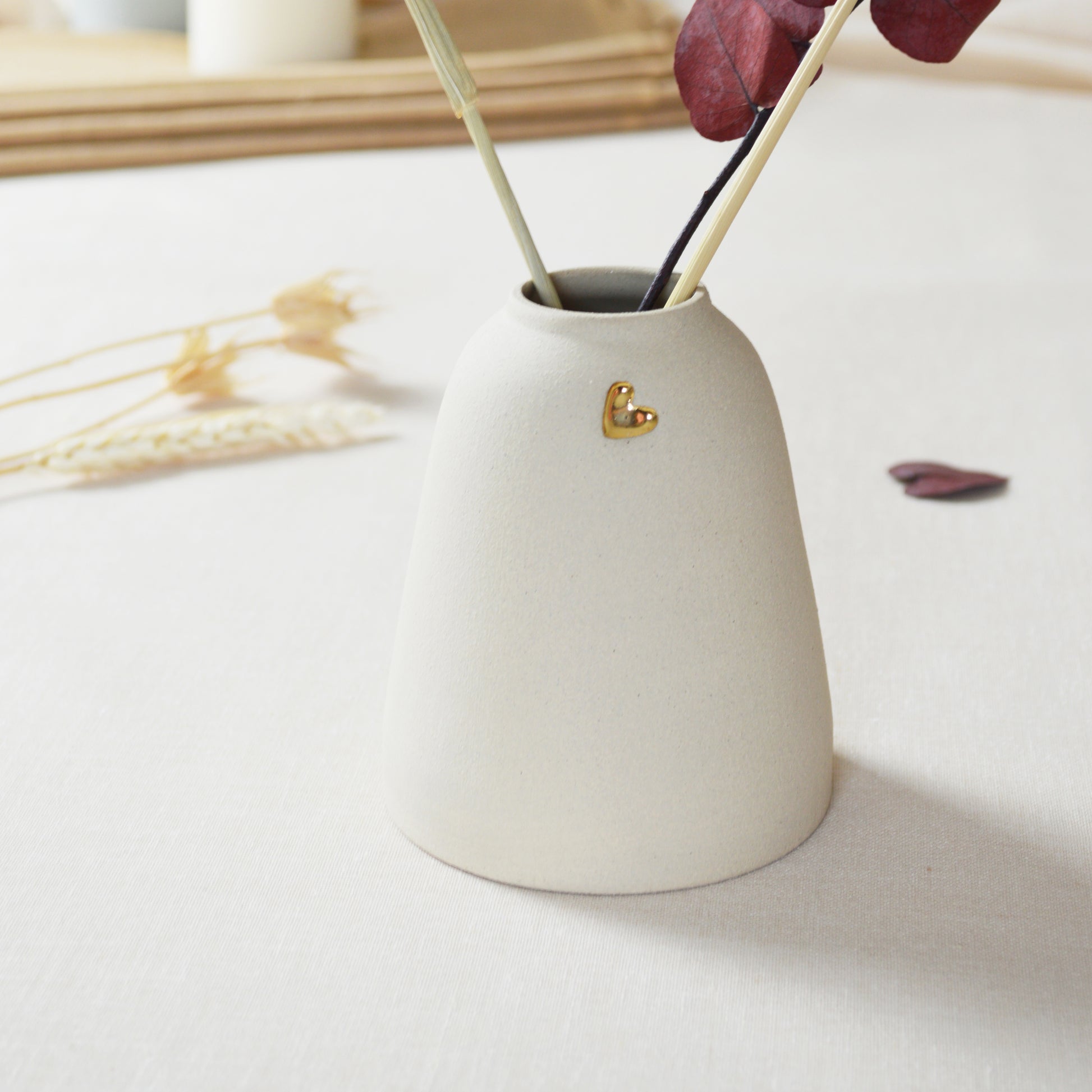 Handmade cream ceramic vase with a gold heart.
